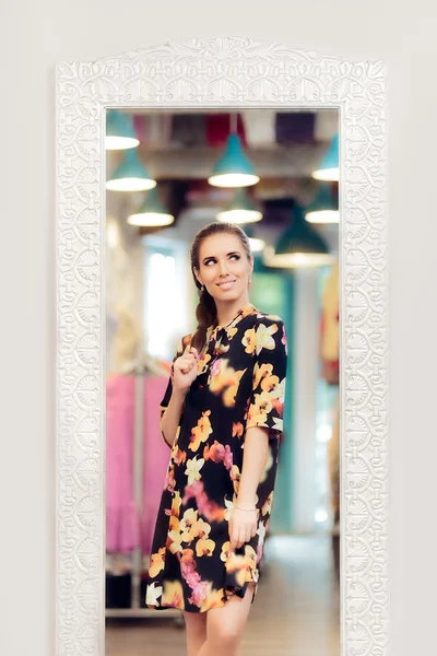 Dziewczyna w kwiatowy wydruku sukienka stojąc przed lustrem — Zdjęcie stockowe