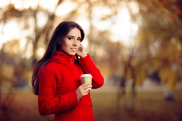 Осенняя женщина держит чашку кофе на природе — стоковое фото