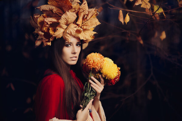 Portrait of a fall princess with foliage wreath with floral bouquet