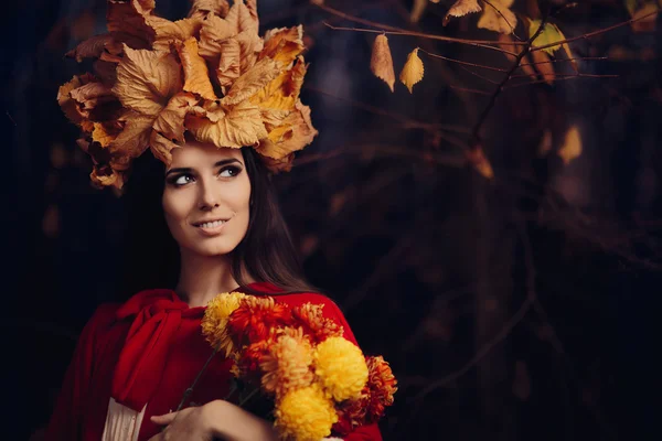 Mulher bonita com outono deixa coroa segurando flores — Fotografia de Stock