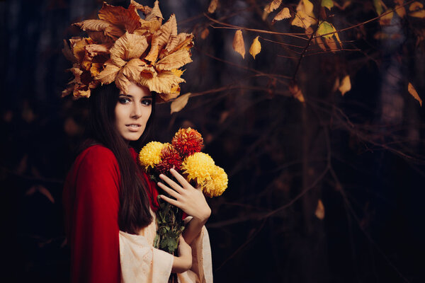 Portrait of a fall princess with foliage wreath with floral bouquet