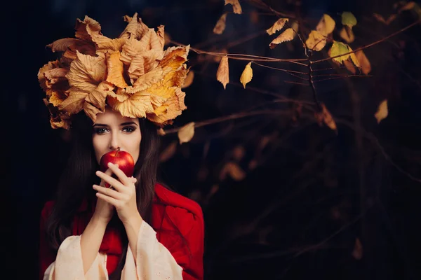 Mulher com outono deixa coroa comendo uma maçã — Fotografia de Stock