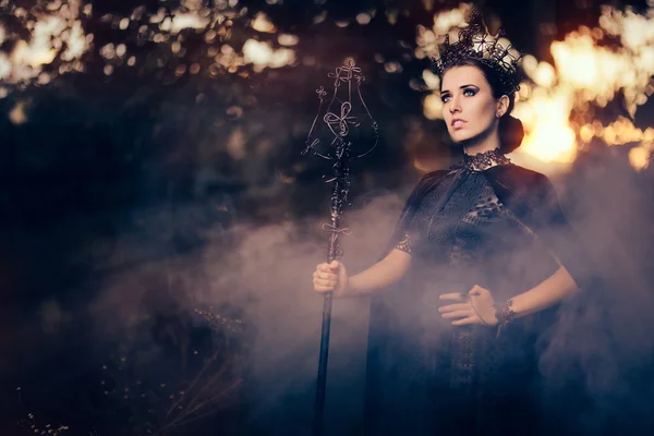 Malvada reina sosteniendo cetro en bosque brumoso — Foto de Stock