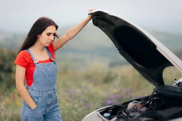 Unhappy Woman Looking Under the Hood of the Car
