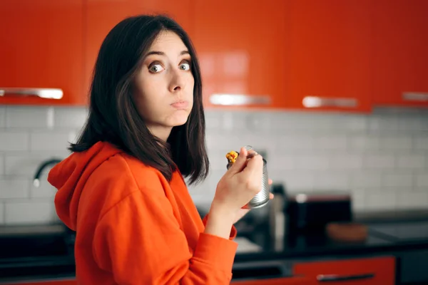 在厨房里吃罐头的闷闷不乐女人 — 图库照片