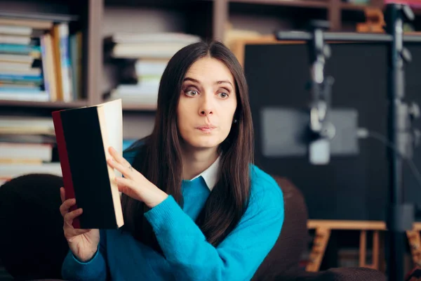 Female Educator Teaching Online Course Holding a Book