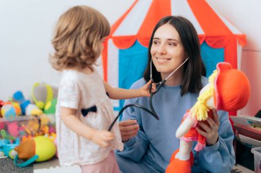 Steteskoplu neşeli anne ve oyuncak bebek doktoru. 