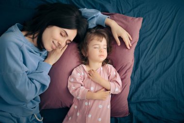 Mother and Daughter Sleeping Peacefully Next to Each Other clipart