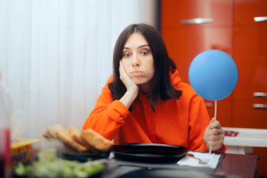 Üzgün kadın balon tutuyor Doğumgününü yalnız geçiriyor 