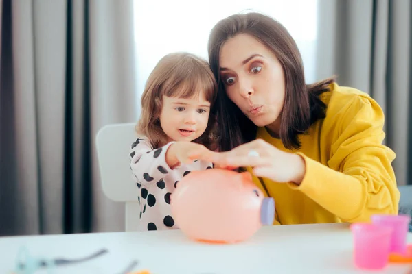 Cheerful Mom and Daughter Learning Financial Education with Piggy Bank