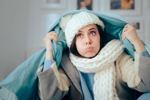 Несчастная женщина чувствует холод носить теплые зимние одежды в помещении