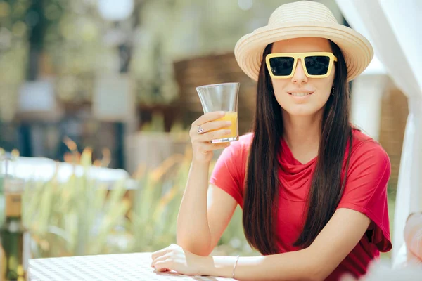 穿着太阳帽和太阳镜的夏季妇女喝橙汁 — 图库照片