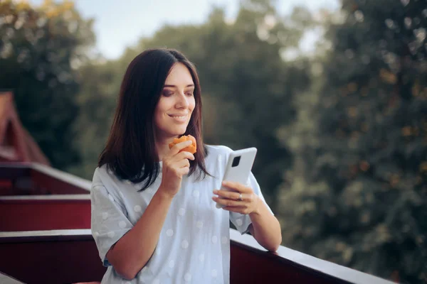 快乐女人吃早餐检查智能手机 — 图库照片