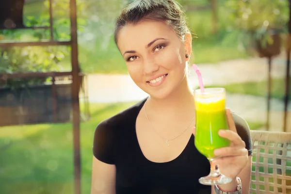 Jonge vrouw met kleurrijke cocktail drinken buiten — Stockfoto