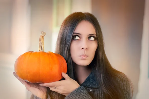 Surprised woman holding a pumpkin — Stock Photo, Image