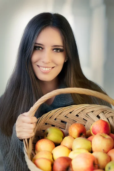 Jonge vrouw met een korf met rijpe appels — Stockfoto