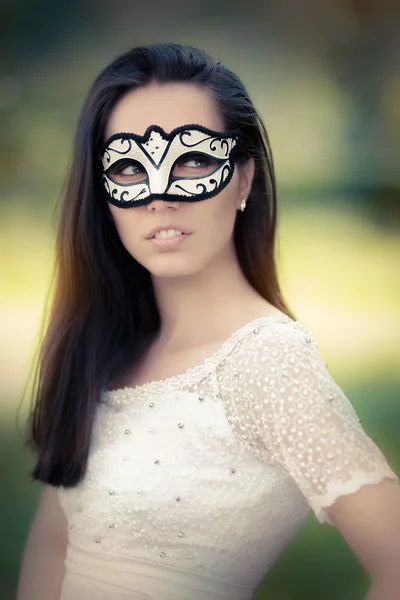 Jonge vrouw in witte jurk dragen masker — Stockfoto