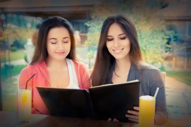 Genç kadın bir restoran menüsünden seçerek