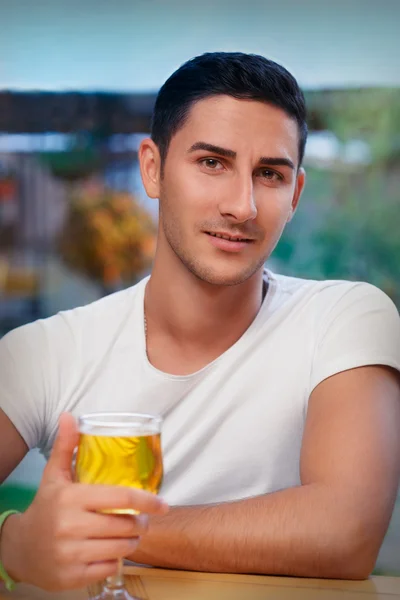 Mladý muž, který držel sklenici v baru — Stock fotografie