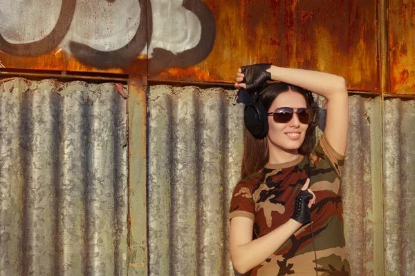 Ung kvinna med stora hörlurar i armén kamouflage T-shirt — Stockfoto