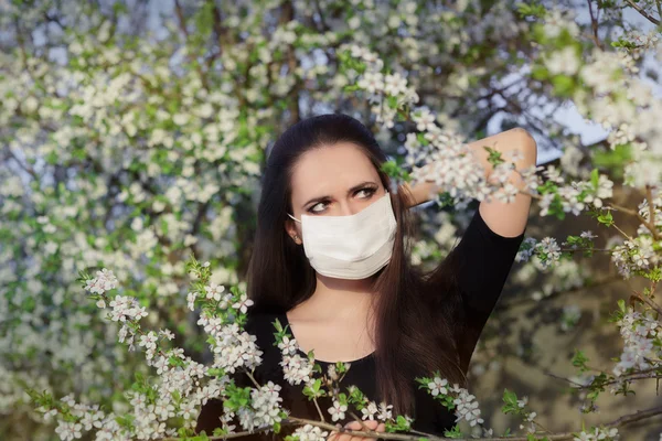 Kadın alerjisi bahar çiçek açan dekorasyonunda solunum maskesi — Stok fotoğraf