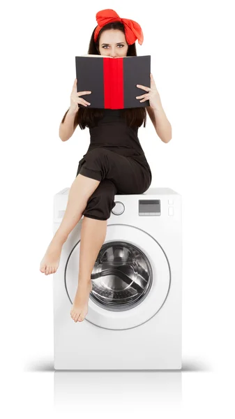 Mädchen liest ein Buch auf einer Waschmaschine — Stockfoto