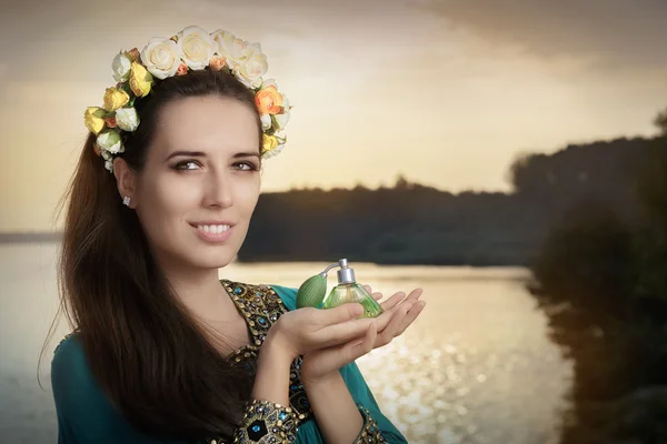 Joven mujer sosteniendo botella de perfume a la luz del sol —  Fotos de Stock