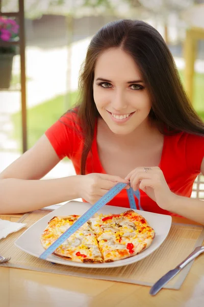 Mladá žena kontroluje na pizzu velikosti s měřicí páska — Stock fotografie