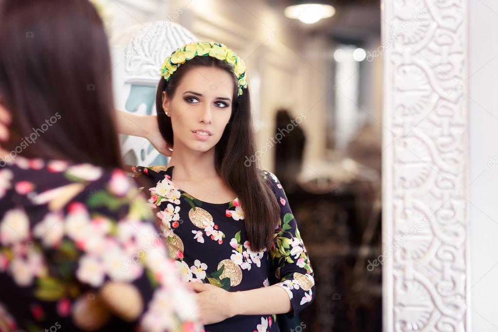 Beautiful Girl Looking in the Mirror and Trying on Floral Dress