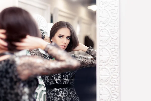 Chica en vestido de encaje negro mirando en el espejo —  Fotos de Stock