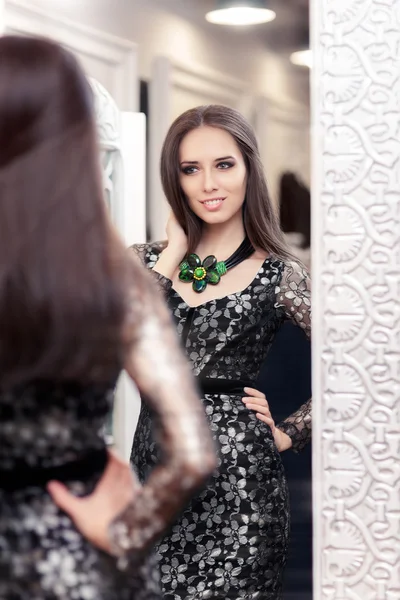 Chica en vestido de encaje negro mirando en el espejo — Foto de Stock