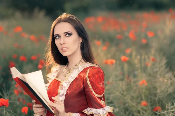 Gyönyörű hercegnő olvasó egy könyv nyári virágos tájon — Stock Fotó