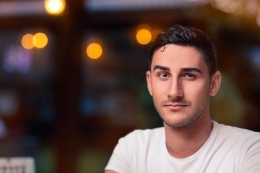Surprised Young Man Sitting in a Restaurant