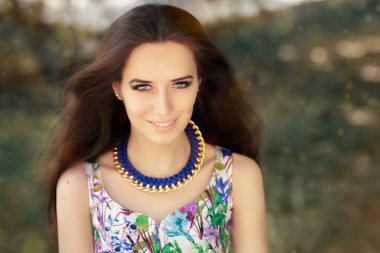 Smiling Woman Wearing Floral Dress and Big Necklace