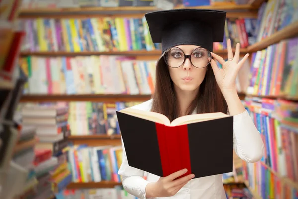 Estudante curioso lendo um livro em uma biblioteca — Fotografia de Stock