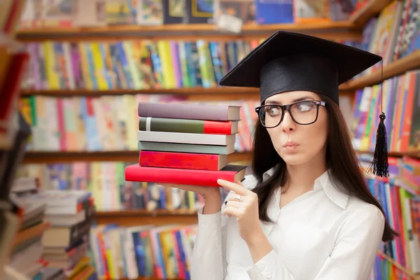 Förvånad Student med examen Cap innehar böcker — Stockfoto