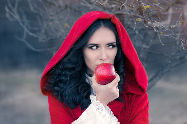 Рыжая женщина в капюшоне держит в руках сказочный портрет Apple

