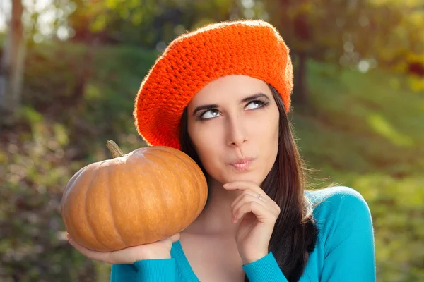 Thinking Woman Holding Pumpkin in Autumn Decor — Stock Photo, Image