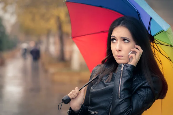 Herfst meisje Holding een regenboog paraplu en een Smartphone — Stockfoto
