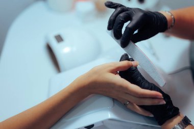 Manikürcü, Salon 'da Tırnakları Düzenli Bir Dosyayla Şekillendiriyor
