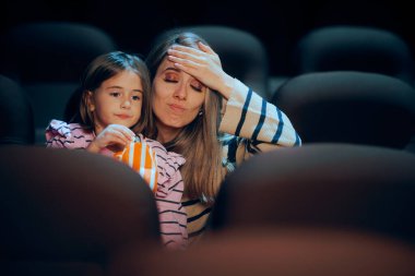 Anne, kızının bir sinema salonunda yüksek sesle çiğnemesini onaylamıyor.