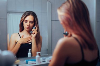 Astım hastası bir kadın evde astım spreyini kullanıyor.