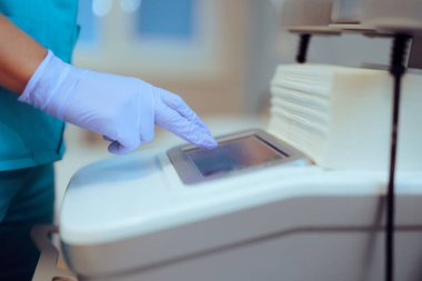 Hastanede tıbbi makineyi çalıştıran bir hemşirenin eli