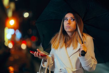 Şaşkın kadın elinde telefonu ve şemsiyesi