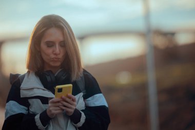 Günbatımında Yürüyüş yapan Kadın Telefonunda Bilgi Arıyor