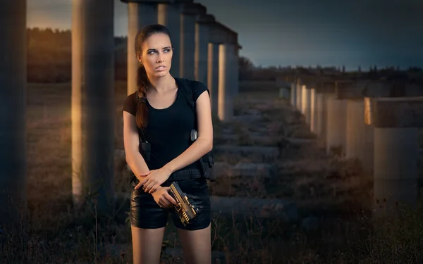 Potente donna che tiene pistola stile film d'azione — Foto Stock