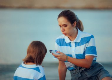 Anne, kızındaki semptomları kontrol etmek için termometre kullanıyor.
