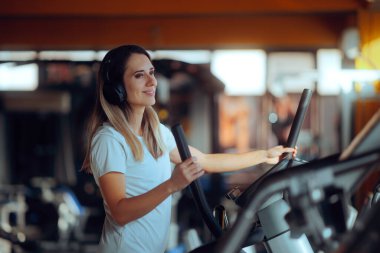 Gülümseyen Kadın Spor salonunda Eliptik Bisikletle Egzersiz Yapıyor