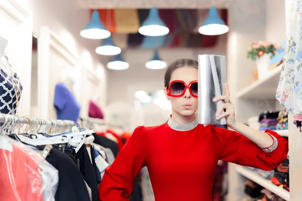 Lustige Modefrau in rotem Kleid mit großer Brille und glänzender Tasche — Stockfoto
