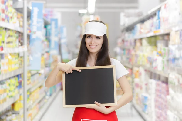 Lachende supermarkt werknemer houden een lege schoolbord — Stockfoto